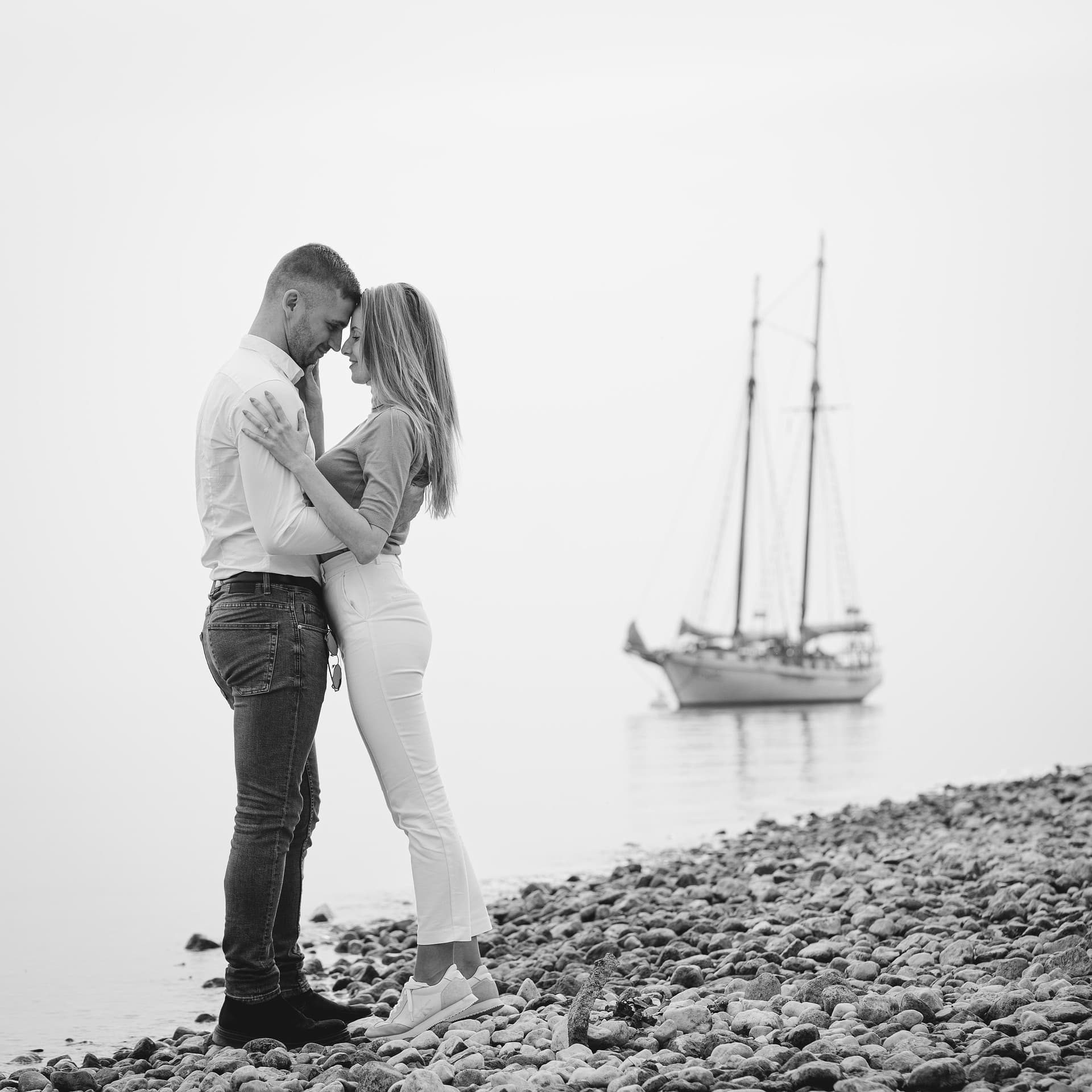 blackwhite-lakeshore-couple-embrace-sailboat.jpg