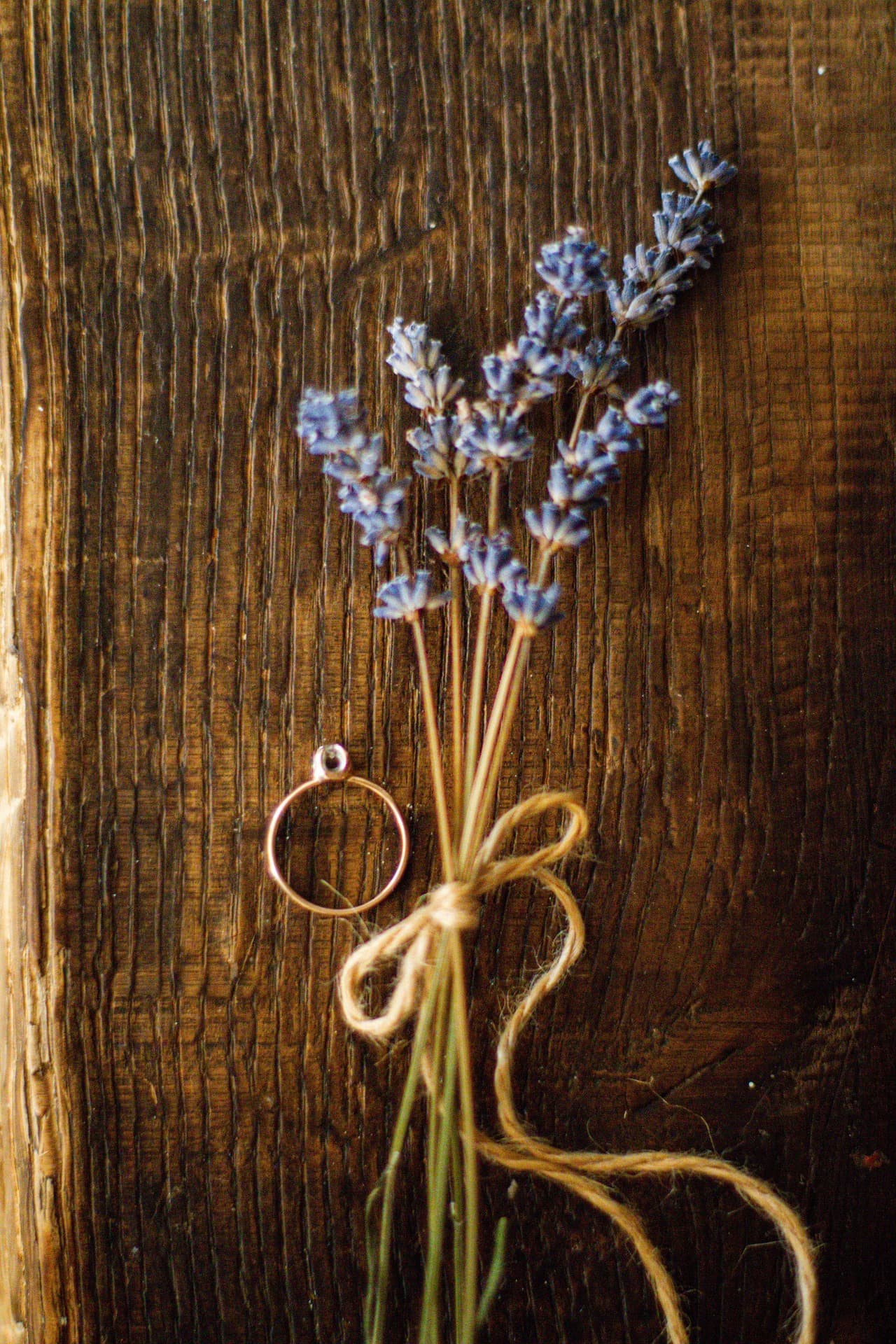 Romantische flatlay met lavendelboeket en verlovingsring op zachte ondergrond